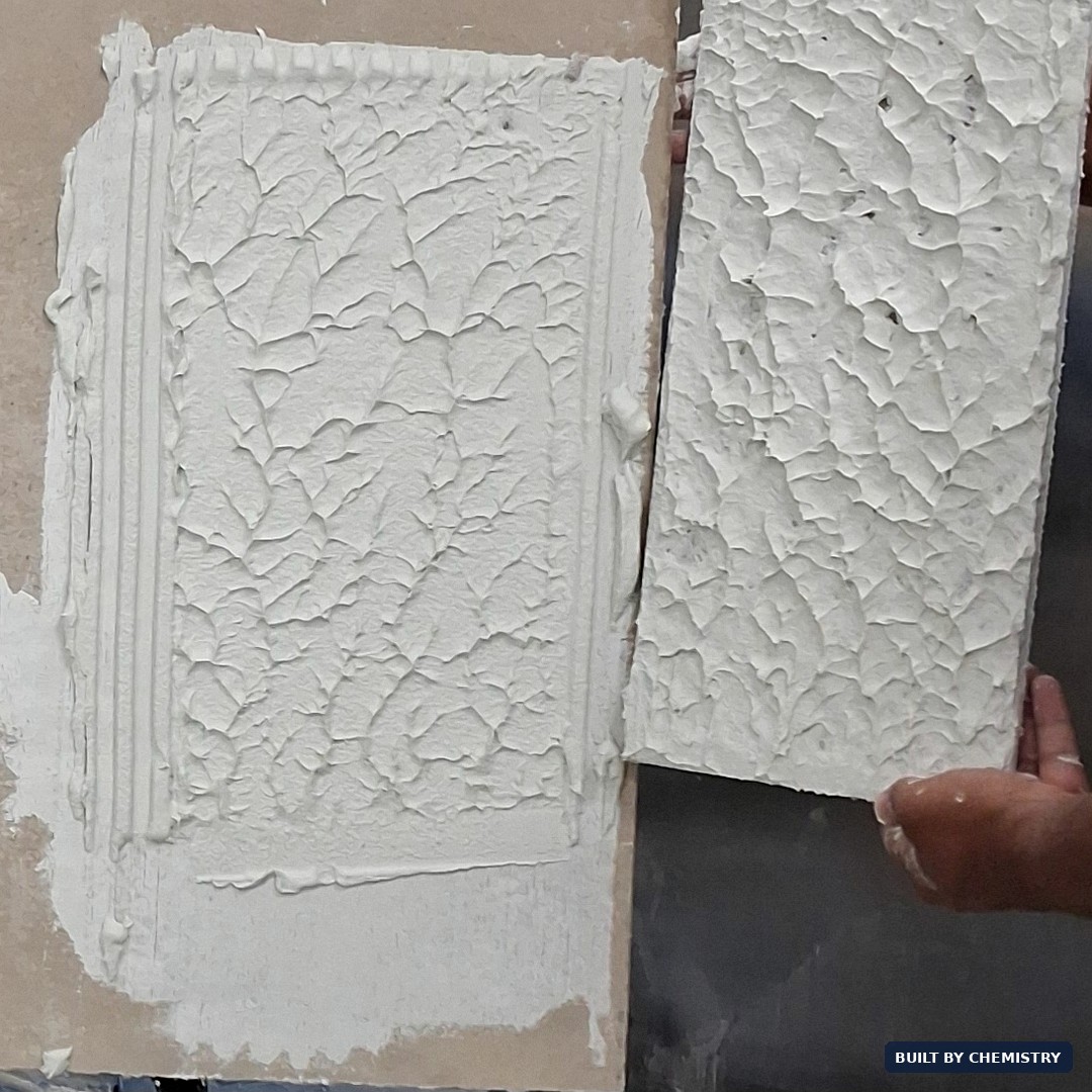Back of a tile lifted from a fresh bed of cementitious adhesive showing 100 percent coverage and perfect transfer — evidence of the cream effect and full wetting typical of a well-formulated thixotropic paste.